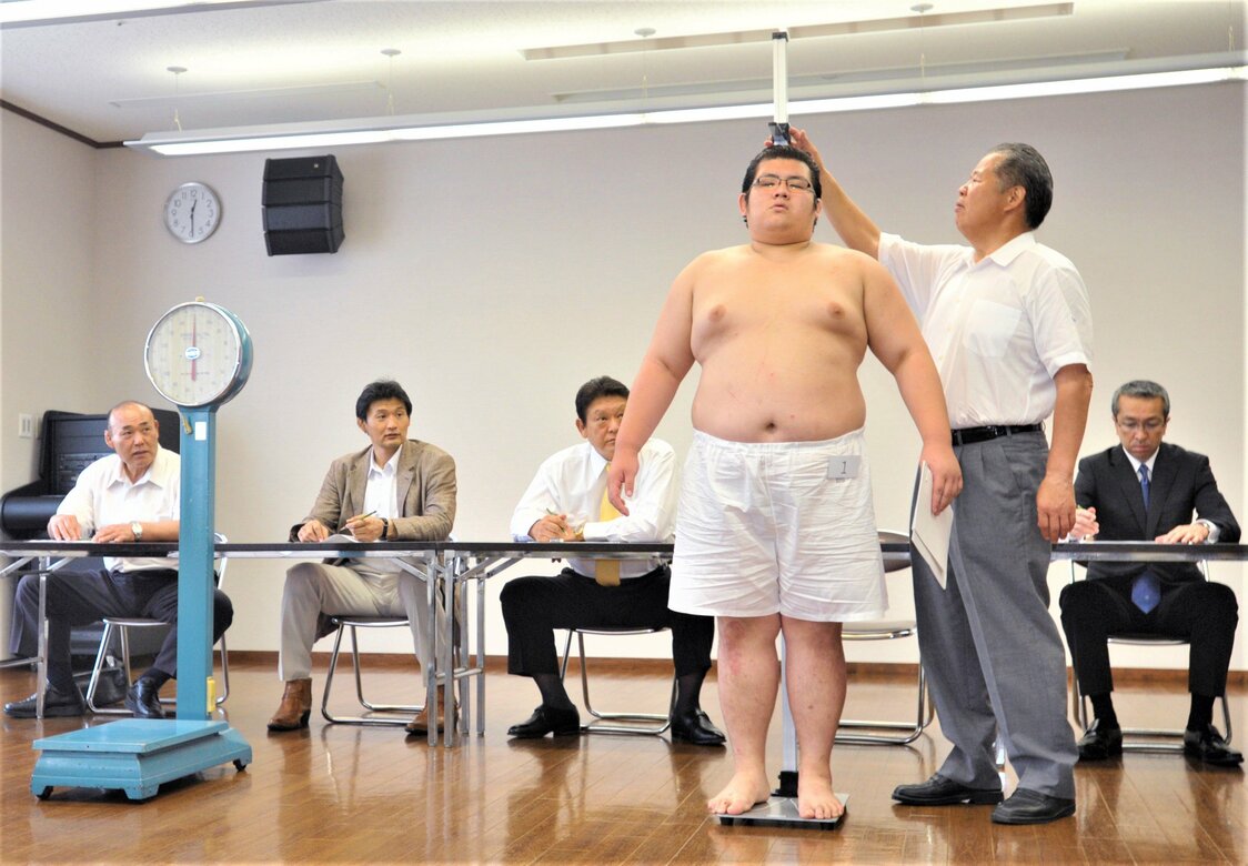 新弟子検査の光景。親方自ら身長計のスライダーを操作し、目盛りを読み上げる（2011年7月4日、名古屋市内） 時事