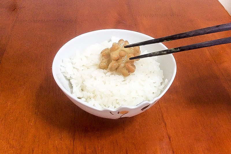 把搅拌好的纳豆放在热乎乎的大米饭上，“开吃”！