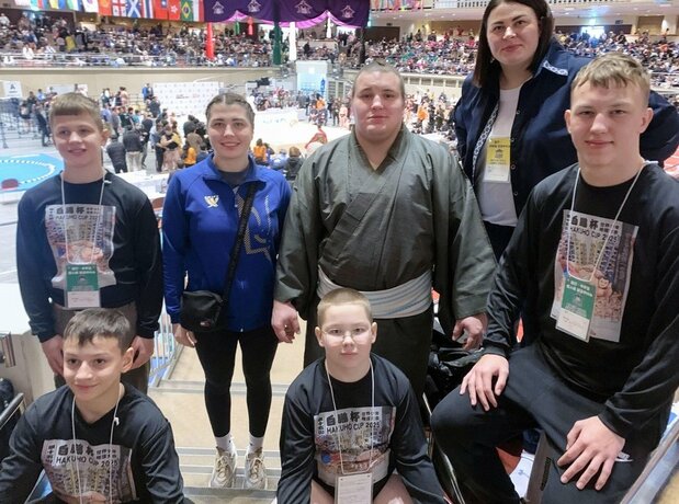 Aonishiki (au second rang, en habit traditionnel) le 11 février 2025 en compagnie de jeunes compétiteurs ukrainiens lors de la coupe Hakuhô pour les écoliers et les collégiens à l’arène de Ryôgoku. (© Kyôdô)