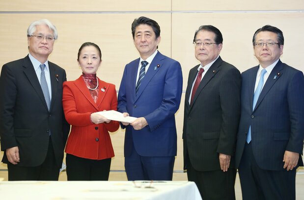 給付型奨学金について検討する自民、公明両党から提言書を受け取る安倍晋三首相(中央)=2016年11月30日、首相官邸で(時事)