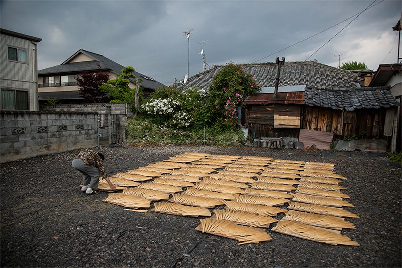 団扇の骨干し作業。朝干し場に出し、夕方取り込む。突然の雨が心配だが、気付かないでいると、「雨が降ってきたよ」と近所の人が声を掛けてくれる