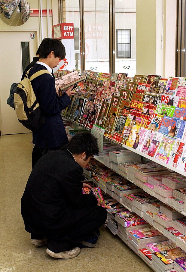 Students read manga magazines in a convenience store in the early 2000s. (© Jiji)