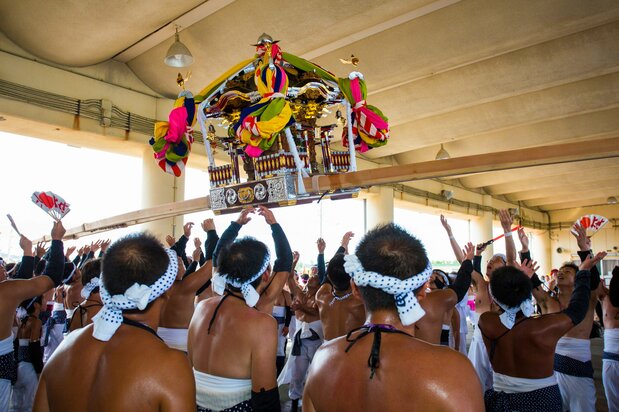 At the fishing port, bearers fling a mikoshi up in the air, praying for bountiful catches and rich harvests. (© Haga Library)