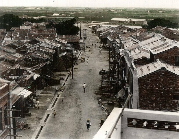 日本統治時代の、現在の民族路。右手前の二階建てが今の「勝豐バー」のある建物。奥の池の向こう辺りが今の復興路で、現在「禾火食堂」がある(「臺灣古寫真上色」提供)