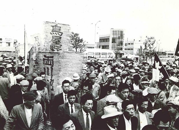 地盤沈下の被害を訴えて、亀田郷土地改良区の組合員は鳥屋野、両川、石山など地区ごとのむしろ旗を掲げ、新潟市内をデモ行進して県庁前広場に向かった。1959年11月19日 新潟市地盤沈下阻止市民大会 提供:亀田郷土地改良区