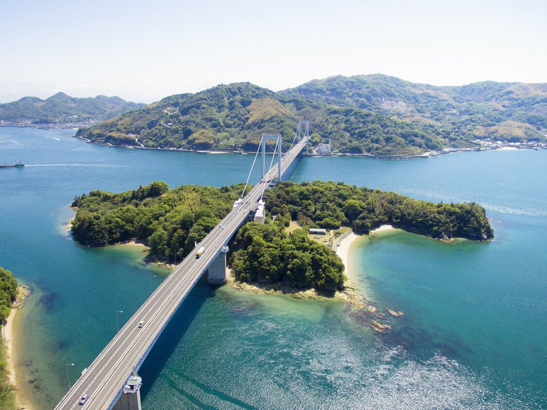 从伯方岛俯瞰伯方大岛大桥。该桥由梁桥和悬索桥组合而成，两种结构在中间的见近岛相接