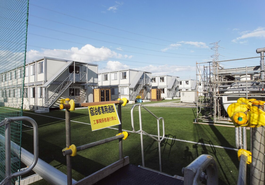 Les préfabriqués destinés à loger les employés de Tepco s’alignent dans le stade (septembre 2011, Jiji).