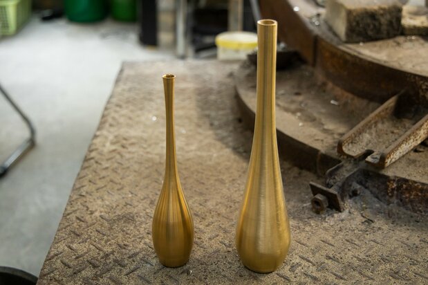 Jinpachi excels at creating delicate bud vases (left). Compared to a popular Takaoka cast metal vase (right), his fine work displays his mastery of the craft.
