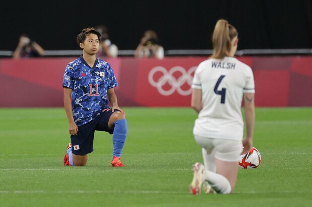 日本国家女子足球队球员田中美南(左)与英国球员在赛前单膝跪地抗议种族歧视(2021年7月24日,北海道札幌巨蛋体育场)AFP/时事社