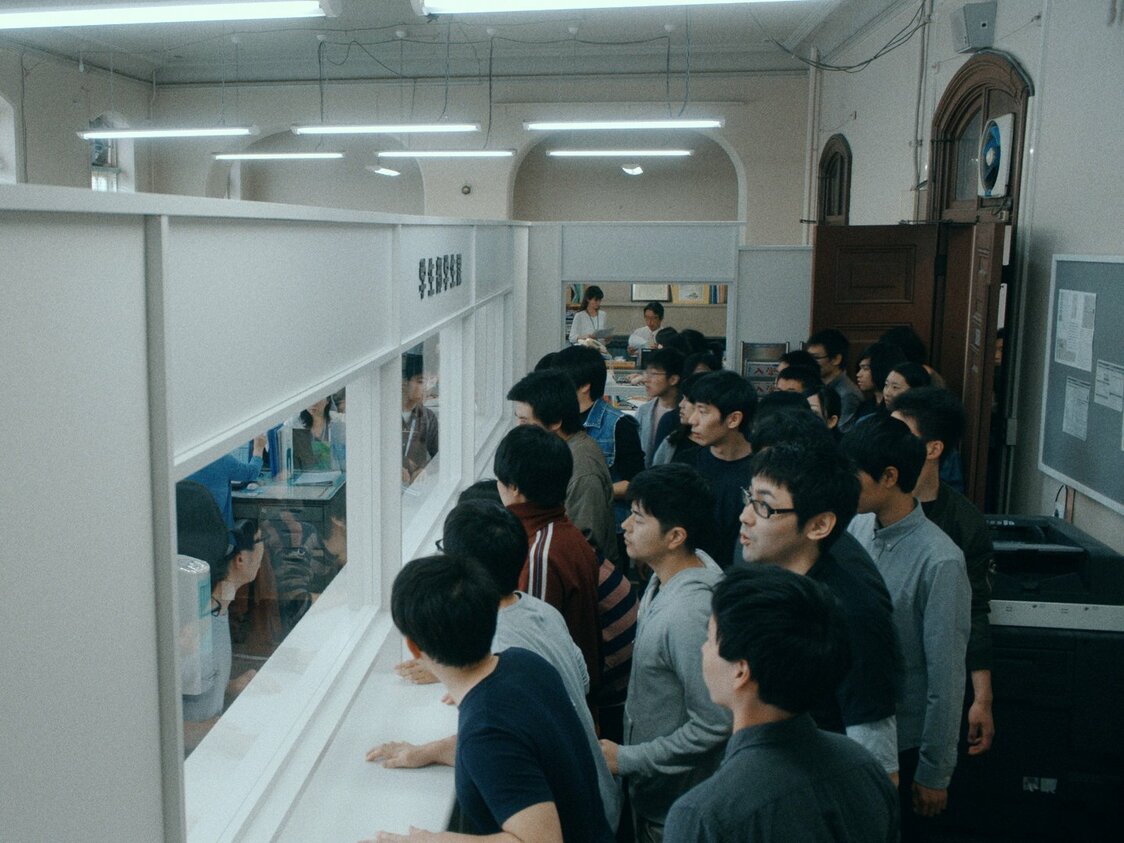 退去通知を受け取った寮生たちは学生課に抗議に向かうが、そこには壁が出現していた　©2018 NHK