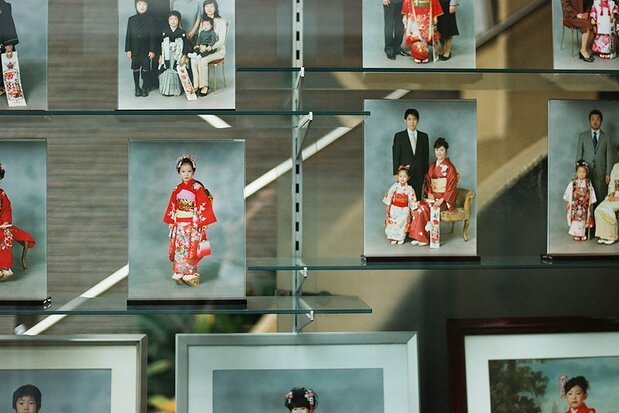 写真スタジオ:5歳の男の子は羽織とはかま、7歳の女の子は着物に帯を身に着ける