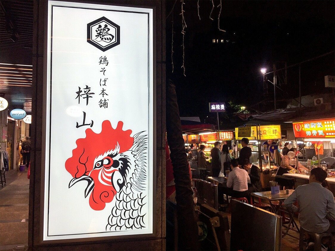 筆者が訪れた鷹峰さんが台北・雙城街の夜市にあるラーメン店・鶏そば本舗＜梓山＞の看板。デザインは鷹峰さん本人によるもの（筆者撮影）