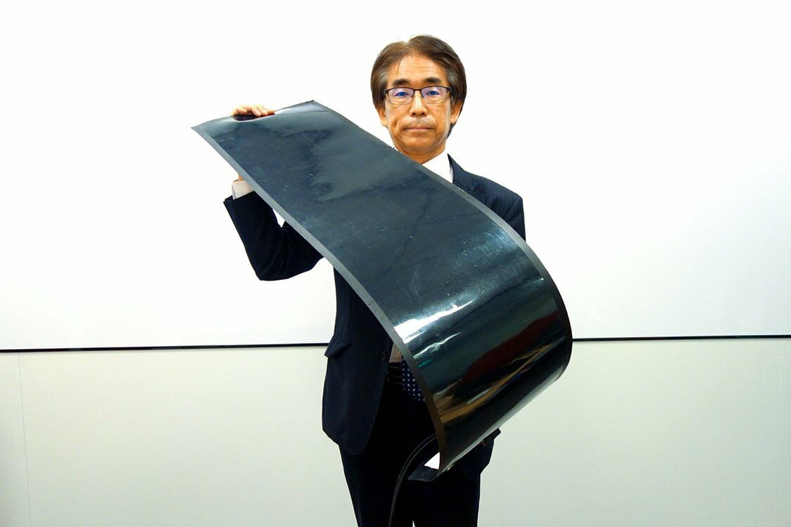 「曲がる太陽電池」の試作品を手にする積水化学工業の森田健晴氏（筆者撮影）