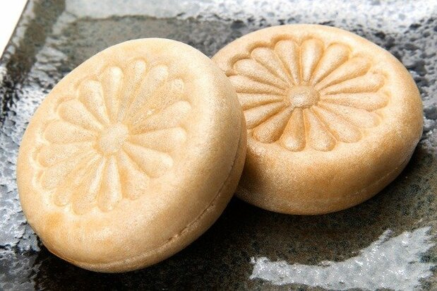 A monaka decorated with a chrysanthemum crest design.