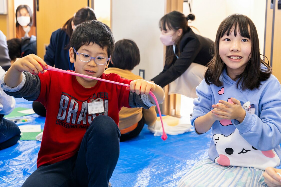巨木の上に、さまざまな色・形状の粘土細工が並んだ作品