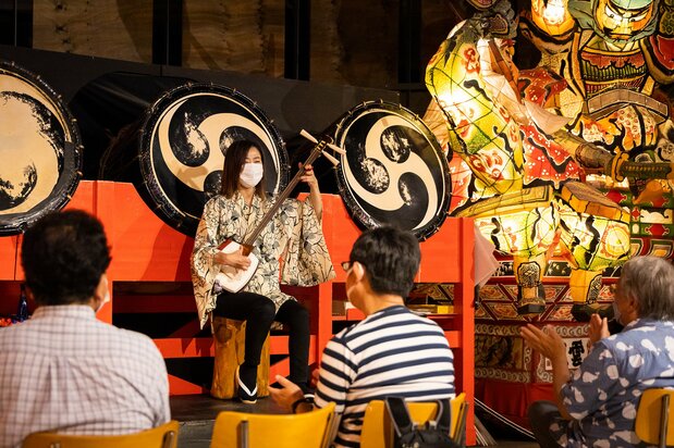 現在は、ねぷたの館で開催している津軽三味線の生演奏。写真の山田里千美(さちみ)さんは、津軽三味線全国大会の女性部門で2連覇を達成した名手だ