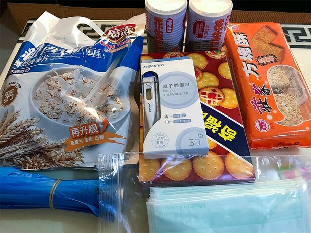 Contenu de la boîte de « bienvenue » : des flocons d'avoine, des biscuits, des sacs à ordures, des masques et un thermomètre.