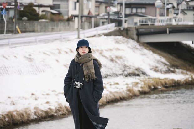 映画『旅と日々』。脚本家の李(シム・ウンギョン)は雪の降る町へと旅立つ © 2025『旅と日々』製作委員会