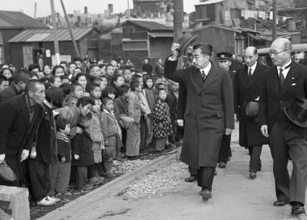 El Emperador Shōwa saluda a la población civil en una zona devastada por la guerra de Yokohama, durante una de sus visitas a las regiones del país en febrero de 1946. (Kyōdō News)