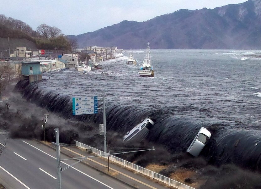 3月11日 下午3时25分左右 岩手县宫古市新川町 巨大海啸袭击宫古市的瞬间。从冲翻的汽车上，不难想象这场海啸的凶猛之势。（照片由宫古市政府职工提供）