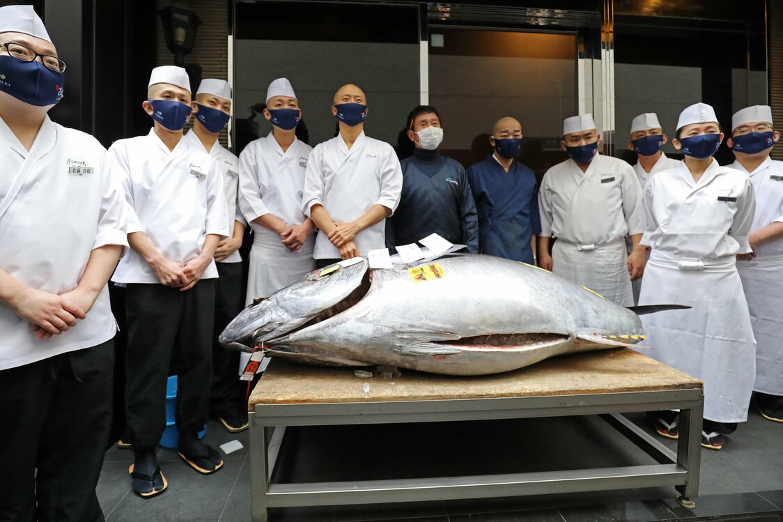 今年の一番マグロが納品された、すし店「銀座おのでら」の前で。中央右の紺色の上着が「やま幸」の山口幸隆社長　写真：時事