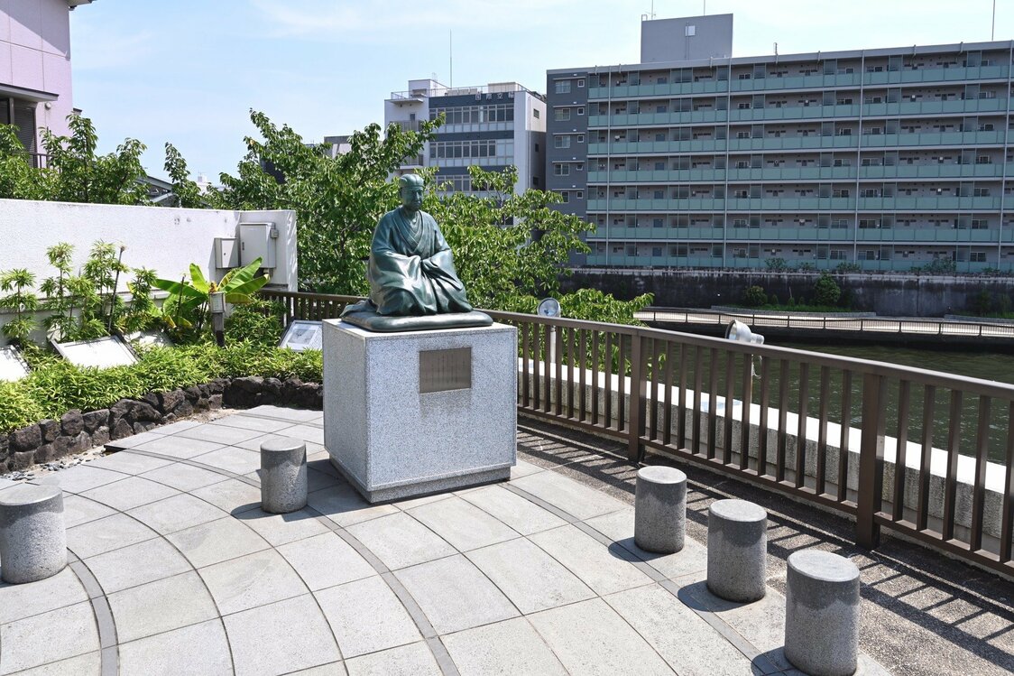 芭蕉庵史跡展望庭園。作品の写真は、右側の柵越しに撮影した。目の前の川は小名木川で、左の塀の上に少しだけ萬年橋の欄干が見える
