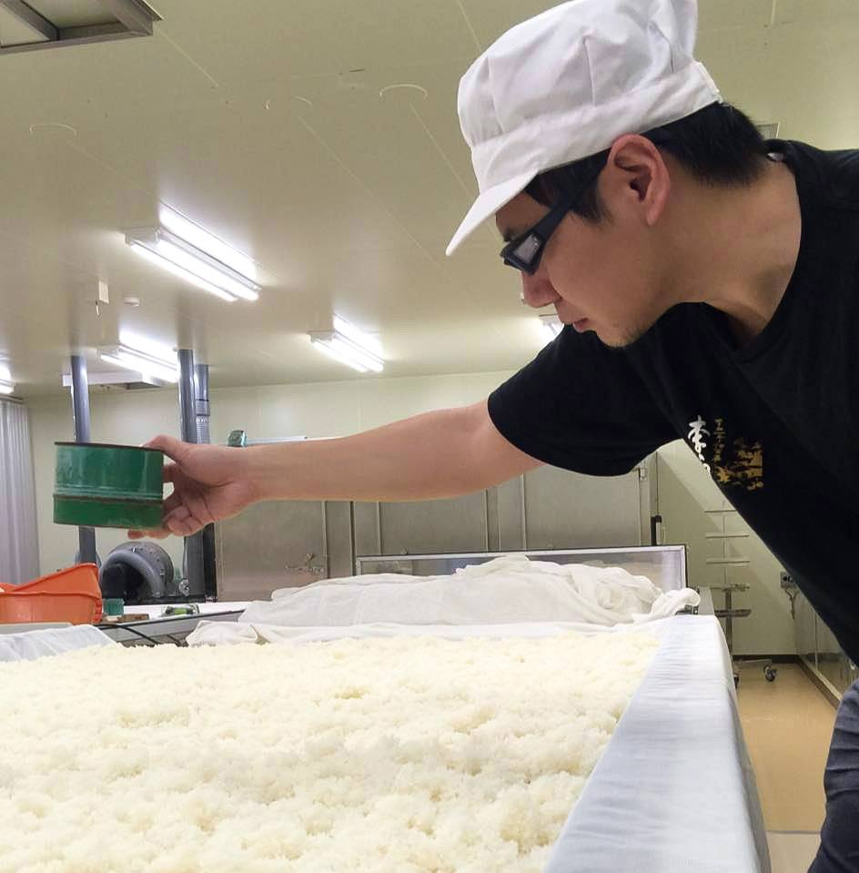 李白酒造にて。蒸米に麹菌をまく「種きり」を行う筆者（筆者提供）
