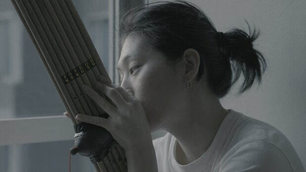 自宅でラオスの民族楽器ケーンを練習するコムアイ ©Toqué Studio LLC