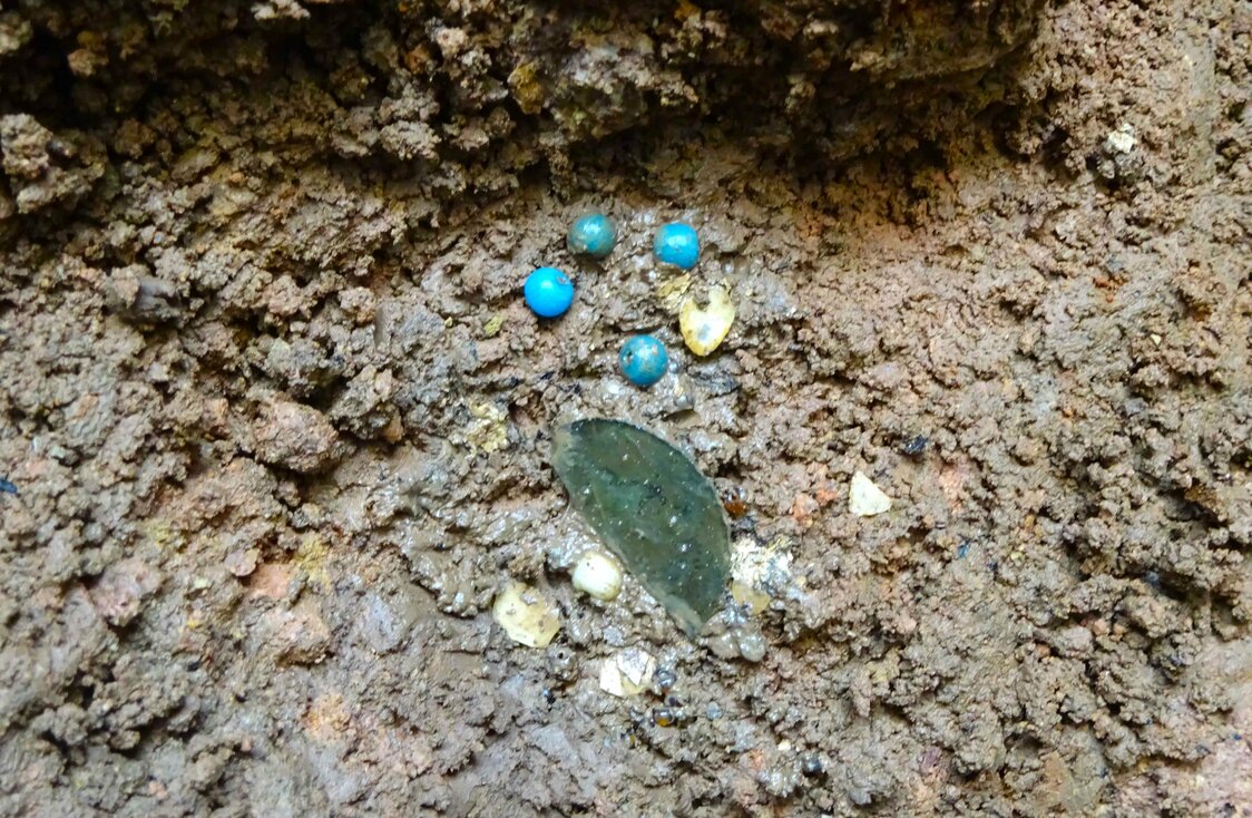 Piezas del ajuar funerario descubierto en uno de los enterramientos. Bolitas de vidrio y fragmentos de una lámina de vidrio. (Cortesía de Asada Masahiko)