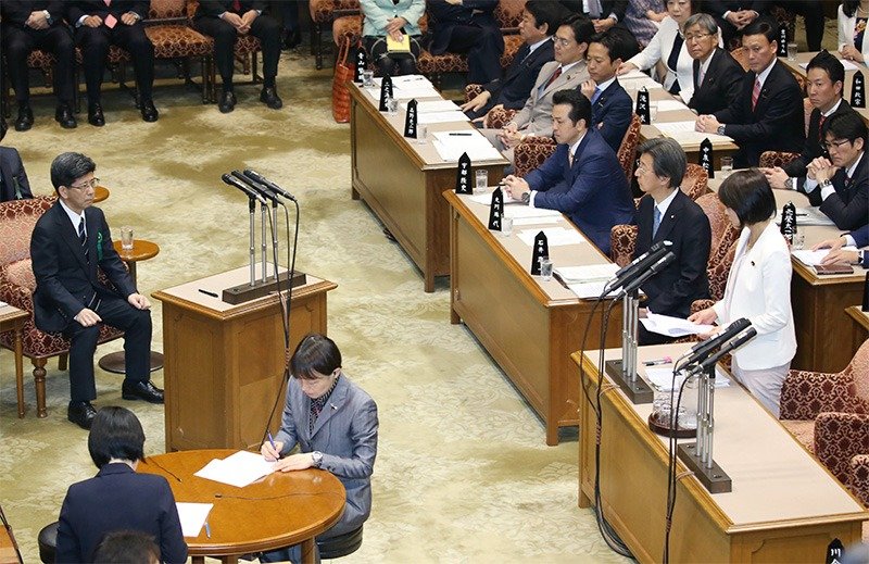 Sagawa Nobuhisa (left) answers questions from Marukawa Tamayo of the LDP (right foreground) in the Diet on March 27, 2018. (© Jiji)