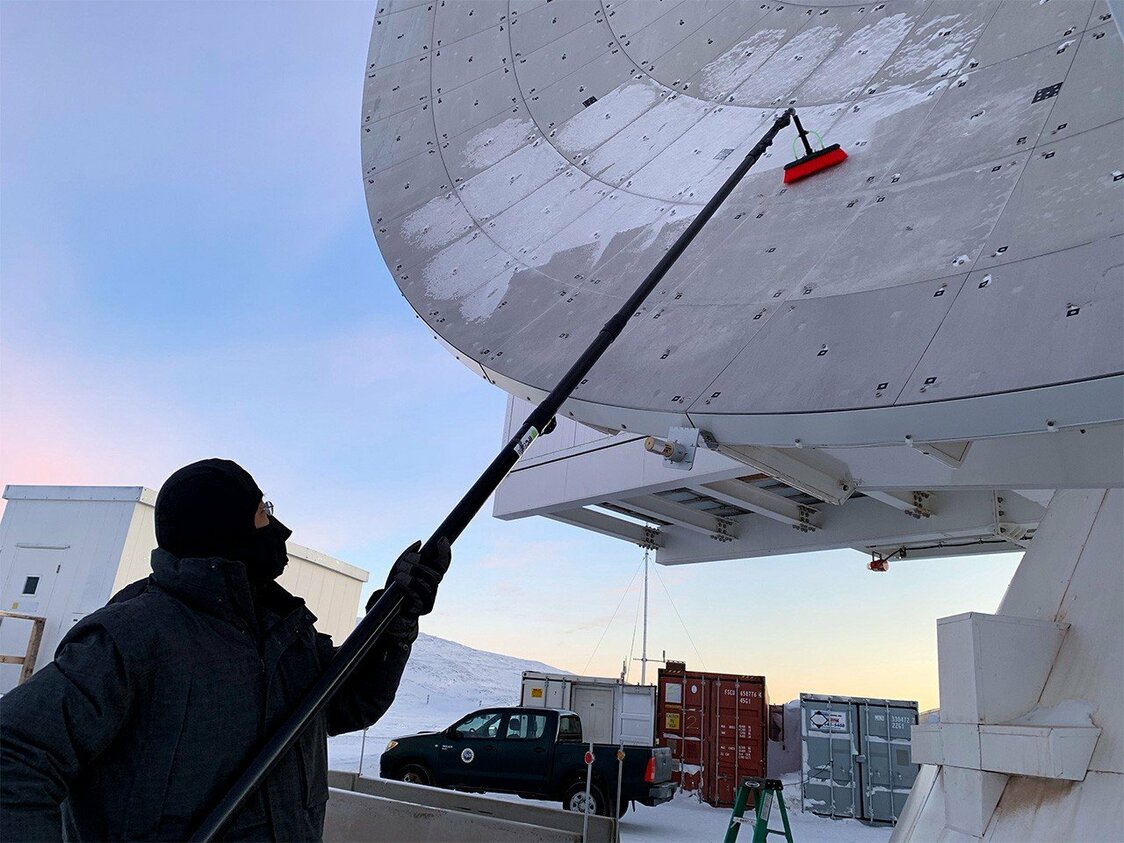 観測のためにGLTの鏡面についた雪を落とす松下聡樹氏