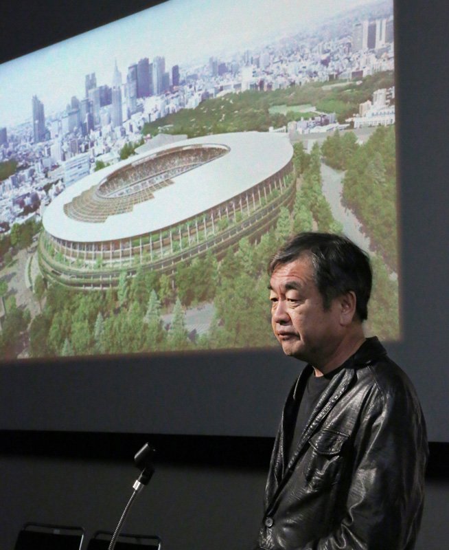 El arquitecto Kuma Kengo habla con la prensa frente a una imagen de su diseño para el nuevo Estadio Nacional el 28 de diciembre de 2015, en Tokio.