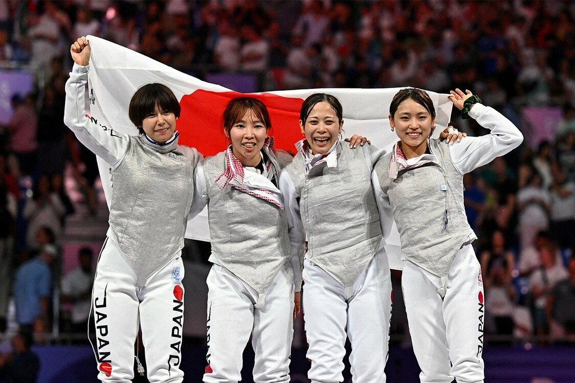 銅メダル決定戦で優勝し、国旗を掲げて喜びを分かち合う、（左から）宮脇花綸、上野優佳、菊地小巻、東晟良。3位決定戦で33-32の超接戦を辛くも逃げ切り、悲願の銅メダルを獲得した。フェンシングで日本女子のメダル獲得は個人・団体通じて初。東、上野、宮脇の3人は個人戦では初戦敗退を喫したが、団体で“借り”を返した。（ロイター）
