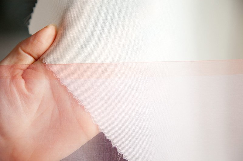 Fairy Feather (at bottom of photo) compared with silk cloth about ten times thicker, made by the same process.