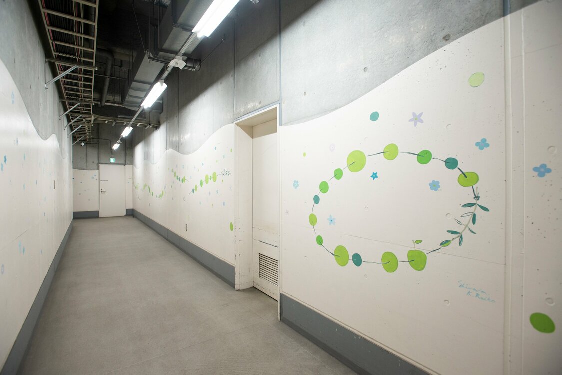 Une peinture murale réalisée par les employés le long du couloir rend hommage aux personnes décédées. (Artiste collaboratrice : Shimada Reiko)