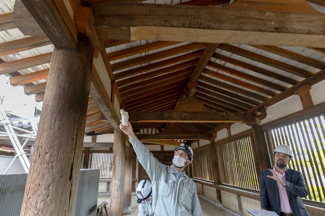 廻廊の仕組みを模型で説明する吉田さん。くぎを使わず木組みで柱やはりを固定するのは日本建築の特徴