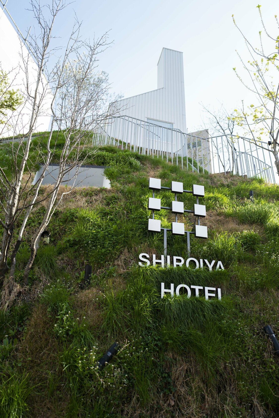 裏手の緑に覆われた土手にホテルやショップが組み込まれている。ユニークな形状は町のランドマークにもなっている