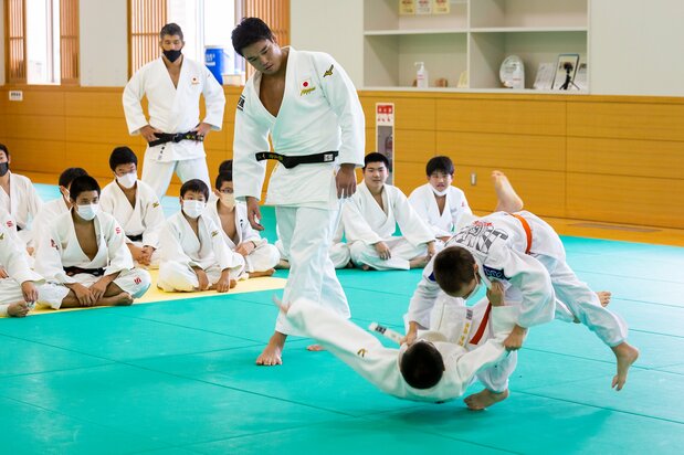 Haga enseña claves de la técnica uchimata. Inoue observa desde atrás.