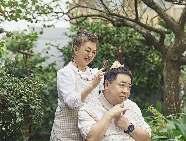 庭にある梅の木の下で母(加賀まりこ)に散髪をしてもらう忠さん(塚地武雅) ©2021「梅切らぬバカ」フィルムプロジェクト