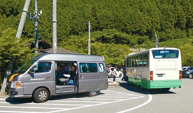 Residents transfer from the community bus (left) to scheduled bus services at Michi no Eki Yoshinoji Kurotaki. (© NPO Hito to Michi Kenkyūkai)