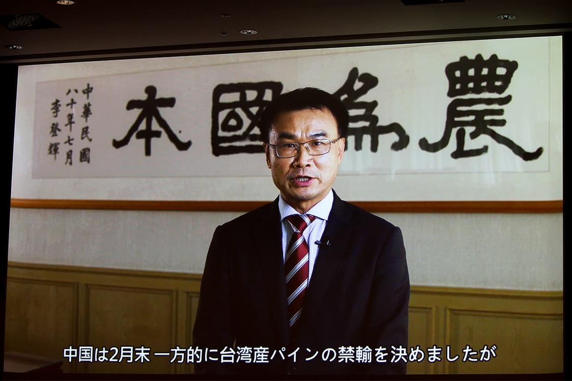 農業委員會陳吉仲主任委員以視訊形式向來賓問候，2021年3月30日，於東京都內飯店舉辦的「臺灣鳳梨以及鳳梨加工品發表會」上播放（編輯部攝影）