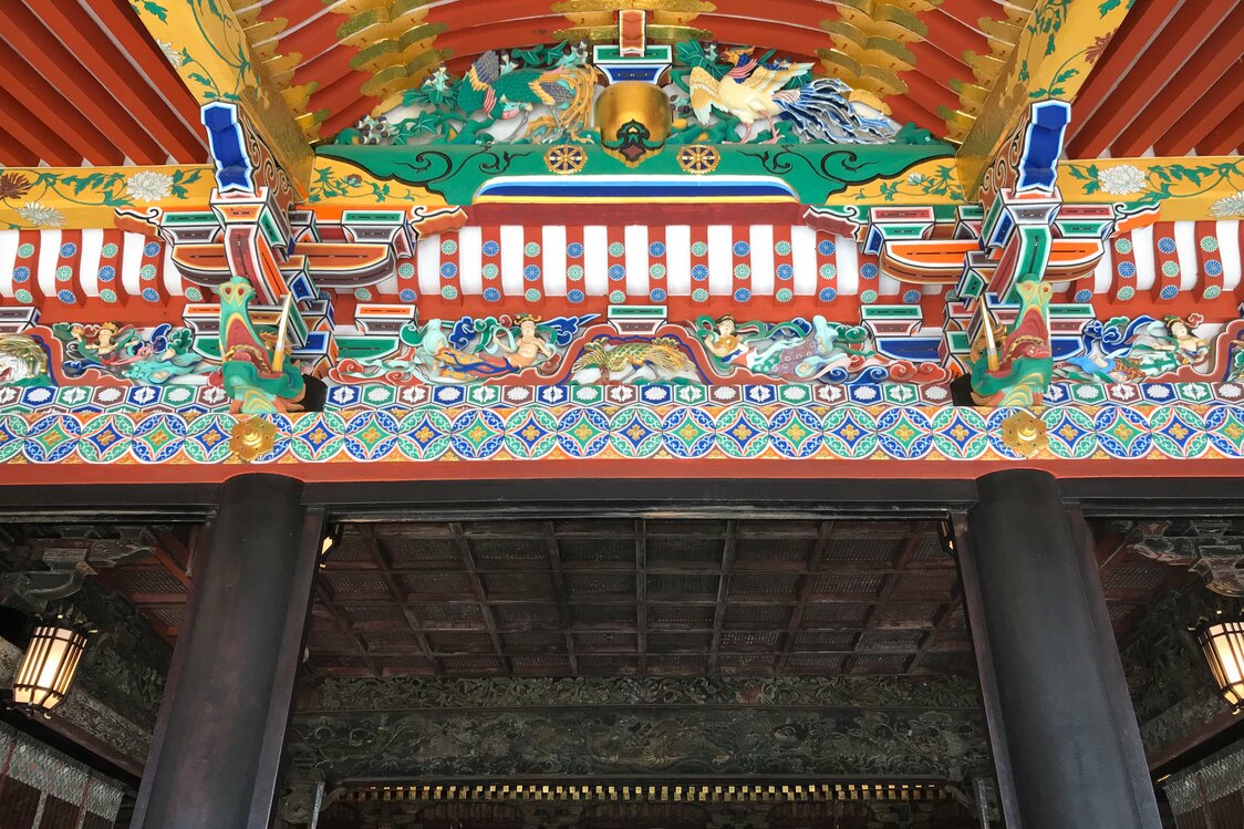 El vano debajo del techo de la fachada de la capilla está lleno de tallas de colores. (Fotografía por cortesía de Ōsaki Hachimangū)