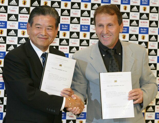 日本代表監督就任会見で川淵三郎日本サッカー協会会長とともに、契約締結書を掲げて握手し、写真撮影に応じるジーコ(2002年7月22日、都内)Reuters