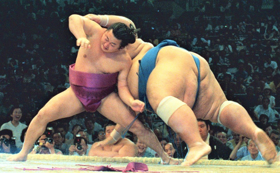 1996年名古屋場所、舞の海は284kgの小錦の寄りを土俵際で残すと、逆転の下手ひねり。左膝に小錦が倒れ込んで靱帯損傷の大けがを負い、十両へ陥落したものの、不屈の闘志で幕内に返り咲いた　共同