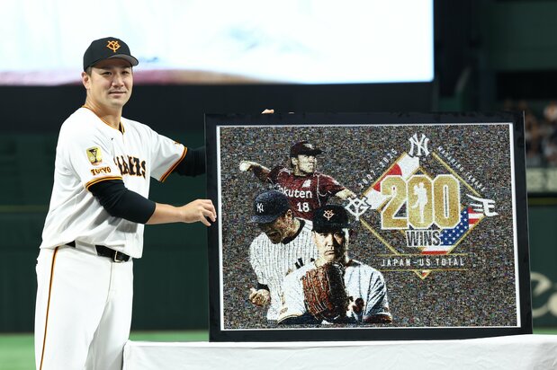 前日に日米通算200勝を達成し、セレモニーでモザイクアートを手に笑顔を見せる巨人の田中将大=2025年10月1日、東京ドーム(時事)
