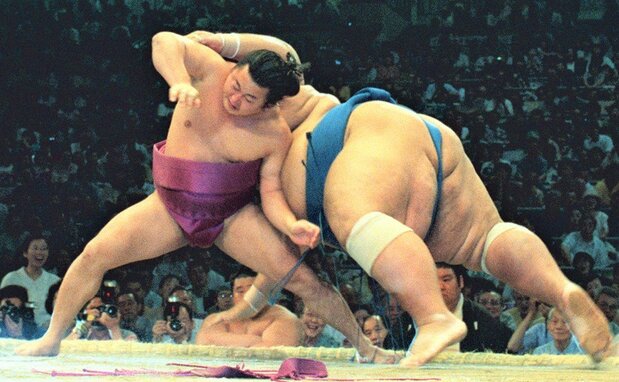 1996年名古屋場所、舞の海は284kgの小錦の寄りを土俵際で残すと、逆転の下手ひねり。左膝に小錦が倒れ込んで靱帯損傷の大けがを負い、十両へ陥落したものの、不屈の闘志で幕内に返り咲いた 共同