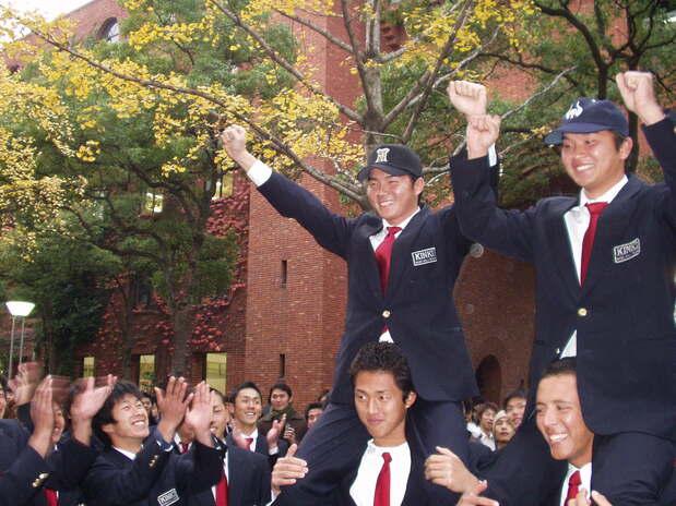 ドラフト会議で阪神タイガースから氏名を受け、仲間から祝福される林威助。右は同期で、大阪近鉄バファローズから指名された大西宏明(林威助提供)