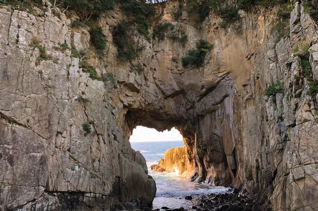A 400 metros al este del faro del cabo Ashizuri se encuentra la puerta de la caverna Shirayama. Dependiendo de la perspectiva, la puerta parece un corazón, por lo que la gente lo considera un lugar de fortuna para atraer el amor. (Imagen de la Asociación de Convenciones Turísticas de la prefectura de Kōchi) 