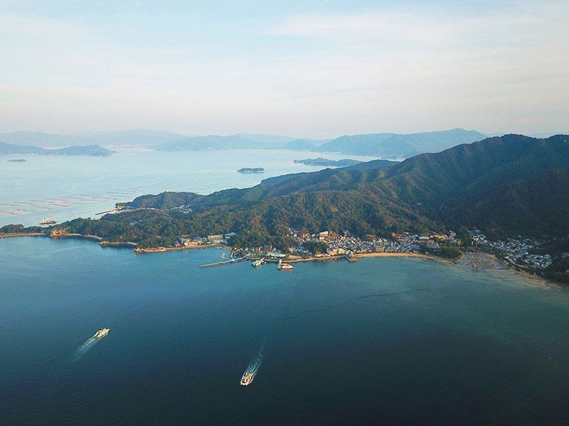 Fotografía aérea de Miyajima y de los ferris que llevan a la isla. A la derecha, el santuario de Itsukushima y su ōtorii.