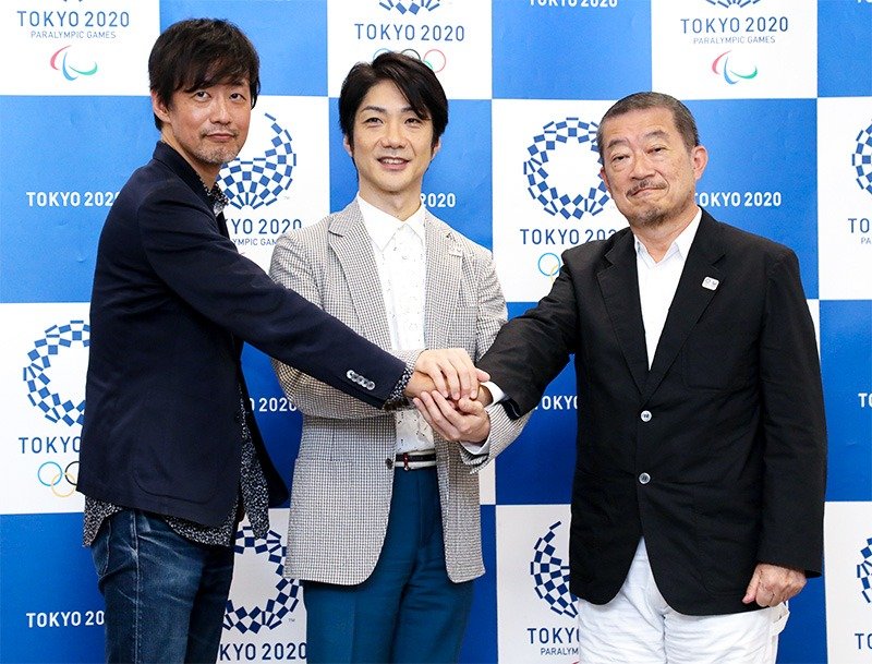 Nomura Mansai (center) at the Tokyo press conference on July 31, 2018, following his appointment as chief executive director for the 2020 Olympic and Paralympic opening and closing ceremonies. Film director Yamazaki Takashi (left) and creative director Sasaki Hiroshi (right) are also part of the team. (© Jiji)